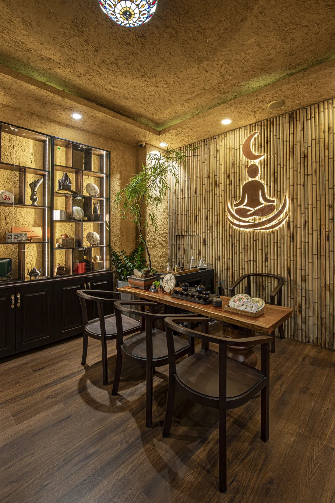 Bàn trà gỗ dài bên bức tường tre và biểu tượng Soulnest